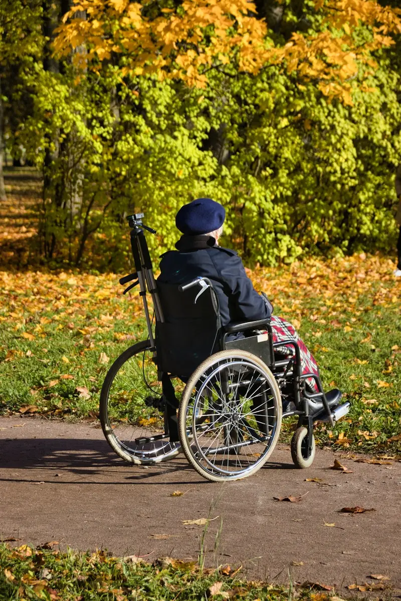 Personne en fauteuil sur un sentier au parc, en automne